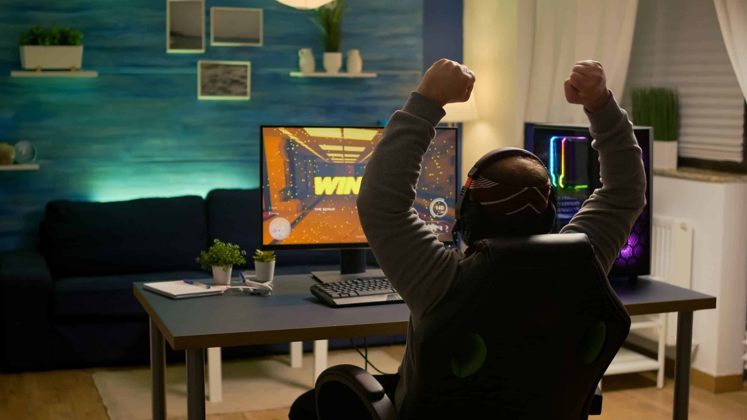, Bismart Videogamer Player Raising Hands After Winning First Person Shooter Competition Wearing Hradphones Professional Pro Gamer Playing Online Video Games With New Graphics On Powerful Computer Scaled